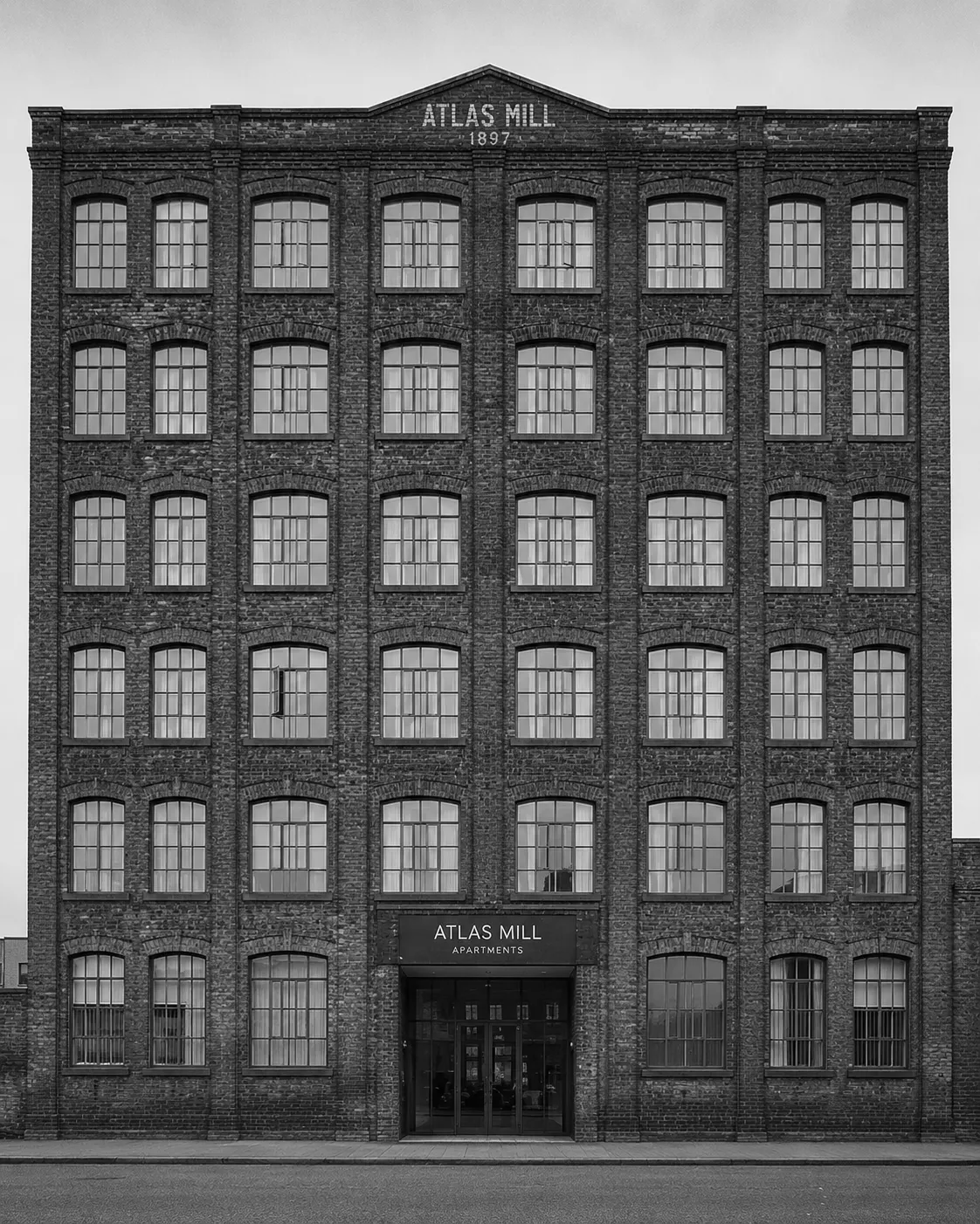 Atlas Mill, Manchester — a converted 1897 cotton mill now apartments. Original 'ATLAS MILL · 1897' carved in stone above the entrance.